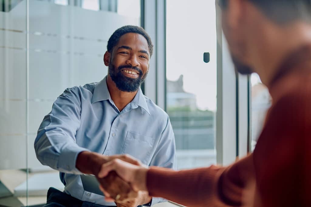 Businessmen shaking hands making partnership agreement in office